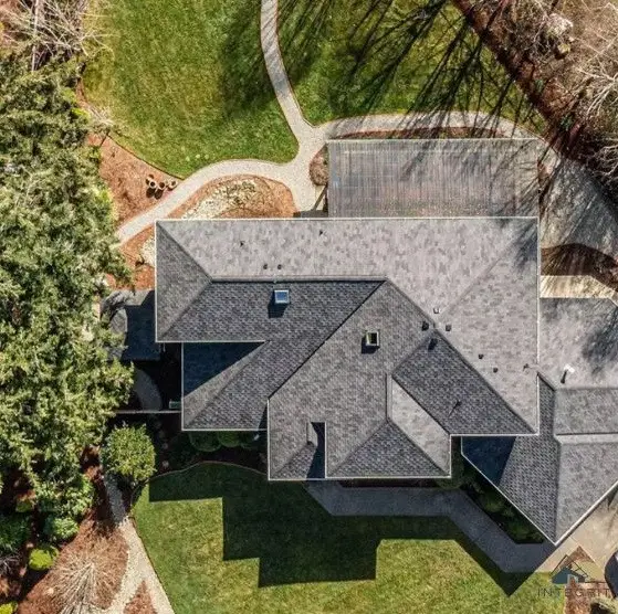 Aerial view of a residential homes new roof surrounded by grass